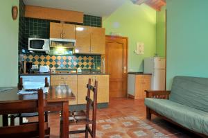 a kitchen and living room with a table and a couch at Apartamentos Al pie de Mañanga in Parres de Llanes +32 photos