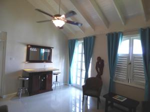 sala de estar con ventilador de techo y TV en Beach One Bedroom Suite A29, en Ocho Ríos