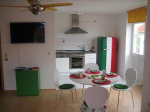 uma cozinha com uma mesa e cadeiras brancas e um frigorífico verde em LITTLE ITALY Studio - EP Ticket Garantie em Rust