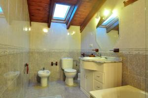 a bathroom with a toilet and a sink and a mirror at Apartamentos Al pie de Mañanga in Parres de Llanes