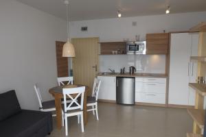 eine Küche und ein Wohnzimmer mit einem Tisch und einem Sofa in der Unterkunft Willa Port in Karwia