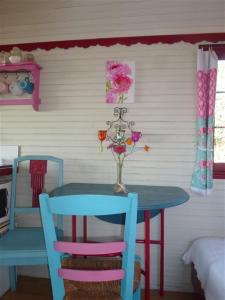 una mesa con dos sillas y un jarrón con flores. en La Petite Fadette, en Sancoins