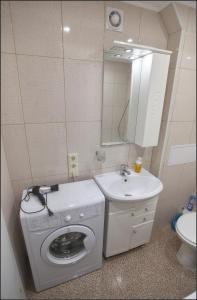 ein Badezimmer mit einer Waschmaschine und einem Waschbecken in der Unterkunft Apartments Morskaya 31 in Sankt Petersburg
