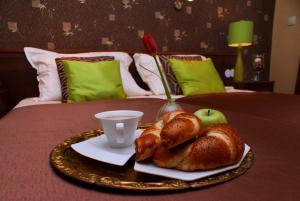 a tray of bread and apples on a bed at Willa Magnolia in Gdynia