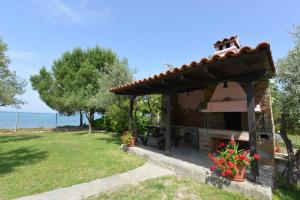 a small house with a garden and the ocean at Haus Katerina in Vourvourou