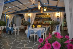 a dining room with white tables and pink flowers at Malia Star Apartments in Malia
