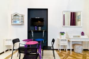 リヴィウにあるStylish Studio near Rynok squareのテーブル、椅子、テレビが備わる客室です。