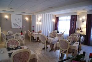 een eetkamer met witte tafels en stoelen bij Hotel des Voyageurs in Tarnac