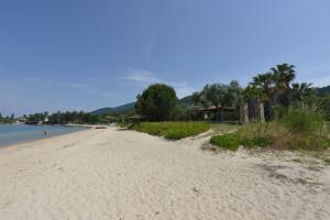 a sandy beach with people swimming in the water at Haus Katerina in Vourvourou
