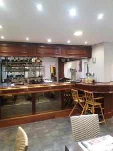a kitchen with a long wooden counter and chairs at L'Ecailler in Ouistreham