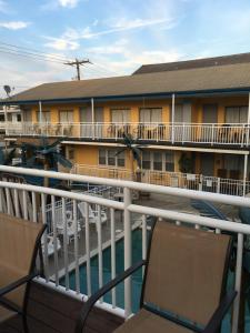 Un balcón de un hotel con sillas y un edificio en Twilight Motel, en Wildwood