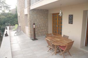 a patio with a wooden table and chairs on a house at La Palma in Ajaccio