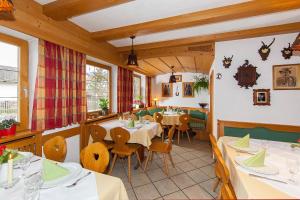 ein Restaurant mit Tischen und Stühlen in einem Zimmer in der Unterkunft Frühstückspension Gästehaus Zum weissen Rössl in Wallgau