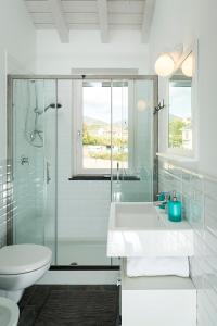 La salle de bains blanche est pourvue d'un lavabo et d'une douche. dans l'établissement B&B VillaRocca da Ines e Perizia, à Sestri Levante