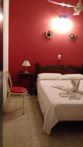 a bedroom with red walls and a bed and a chair at Residencial Castelar in Merlo