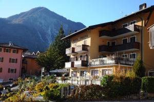 a building with balconies and a mountain in the background at Hotel Cristina in Tenno