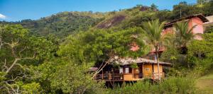 uma casa no lado de uma colina com árvores em Pousada Mariola em Ilhabela