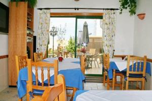 a dining room with tables and chairs and a patio at La Vista Pension in Guía de Isora