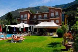 a group of people laying on lawn chairs in front of a hotel at Ambienthotel Luna Rossa in Malcesine