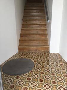 um corredor com piso em azulejo, um tapete e escadas em ValentinaPlace em Alcácer do Sal