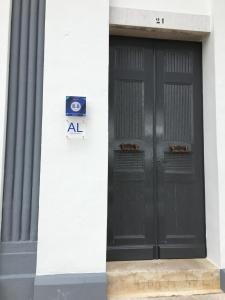 twee zwarte deuren aan de zijkant van een gebouw bij ValentinaPlace in Alcácer do Sal