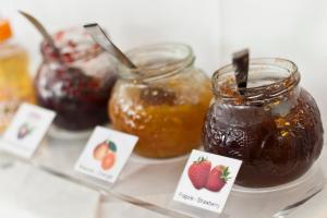 une table avec des bocaux de confiture, de fraises et de miel dans l'établissement Hotel Diana, à Ravenne