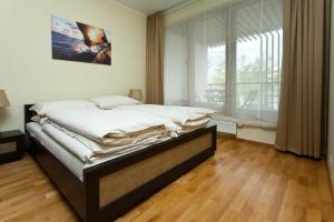 a bed in a room with a large window at Apartamenty Olimpic in Kołobrzeg