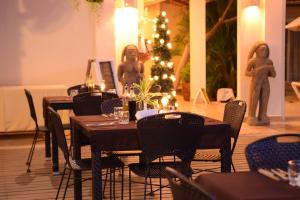 un comedor con mesas y sillas y un árbol de Navidad en Montelaguna Boutique Hotel, en Sámara