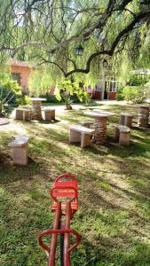 a red stool sitting in the grass under a tree at Residencial Castelar in Merlo