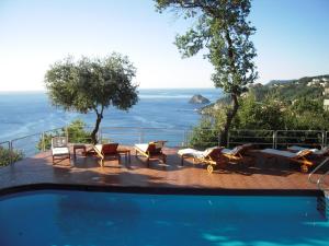 a swimming pool with chairs and a view of the ocean at Hotel Claudio in Bergeggi