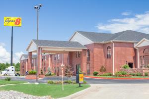 a red brick building with a sign in front of it at Super 8 by Wyndham Lowell/Bentonville/Rogers Area in Lowell