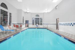 duży basen z niebieską wodą w budynku w obiekcie Super 8 by Wyndham Lowell/Bentonville/Rogers Area w mieście Lowell