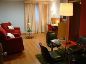 a living room with a red chair and a table at Hotel Reconquista in Alcoy