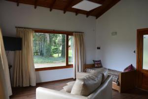 un salon avec un canapé et une grande fenêtre dans l'établissement Cabaña El Tigre, à Tandil