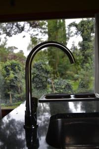 a kitchen sink with a faucet in front of a window at Cabaña El Tigre in Tandil