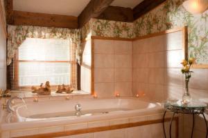 a bath tub in a bathroom with a window at West Hill House B&B in Mad River Valley in Warren +42 photos
