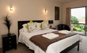 1 dormitorio con 1 cama con toallas en B&B@The Redwoods en Rotorua