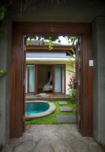 une porte ouverte menant à une maison avec une piscine dans l'établissement Ladera Villa Ubud, à Ubud