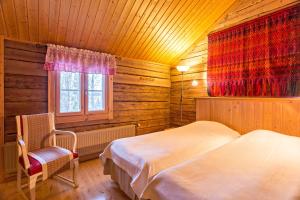 1 Schlafzimmer mit 2 Betten, einem Stuhl und einem Fenster in der Unterkunft Peltolan Luomutila in Vilppula