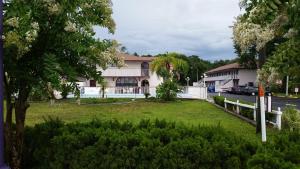 a house with a white fence and a yard at Maple Leaf Inn & Suites in Kissimmee