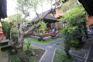 a courtyard of a house with trees and plants at Dewa Hostel in Ubud