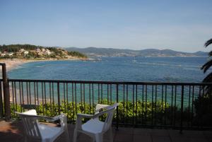a balcony with two chairs and a view of the water at Hostal Carabela in Areas