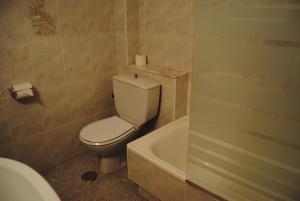 a bathroom with a toilet and a bath tub at Hostal Carabela in Areas +18 photos
