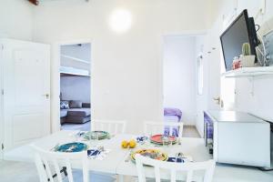 biała kuchnia z białym stołem i krzesłami w obiekcie Isla w mieście Puerto de Mazarrón