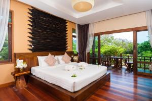 a bedroom with a large bed with white sheets at Palm Leaf Resort Koh Tao in Ko Tao