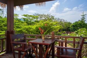 a table and two chairs on a porch with a view at Palm Leaf Resort Koh Tao in Ko Tao