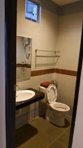 a bathroom with a toilet and a sink and a tv at Anjung Villa in Pantai Cenang