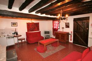 ein Wohnzimmer mit einem roten Sofa und einem Tisch in der Unterkunft Moulin de Moulignon B&B in Messy