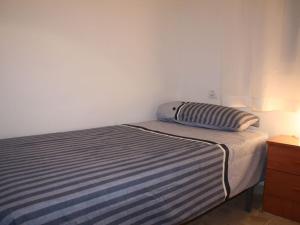 a bed with a pillow sitting on top of it at Apartamento moderno cerca del centro in Málaga