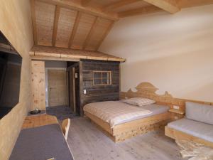 een slaapkamer met een bed en een bank bij Kleines Zirbelhotel - ÜF in Oberammergau
